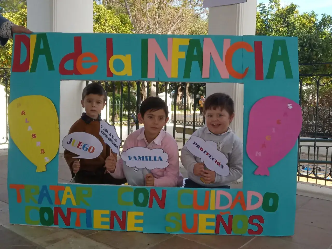 Ni&ntilde;os sonr&iacute;en tras un marco de 